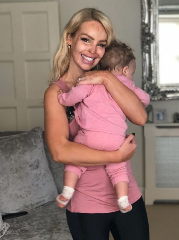 Katie Piper holding a young child dressed in pink