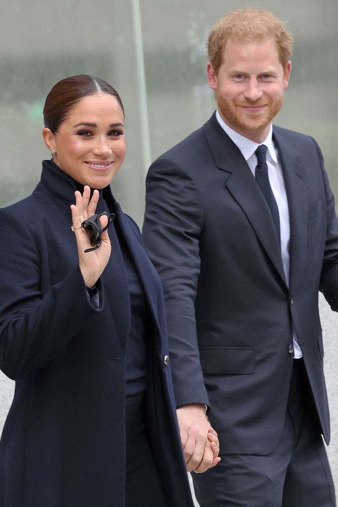 Meghan markle and Prince Harry smiling in black outfits