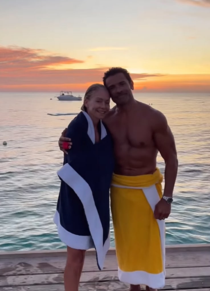 Clip of a video montage shared by Kelly Ripa shared on Instagram September 2023 where she is posing by the water with her husband Mark Consuelos during their beach vacation with their kids.