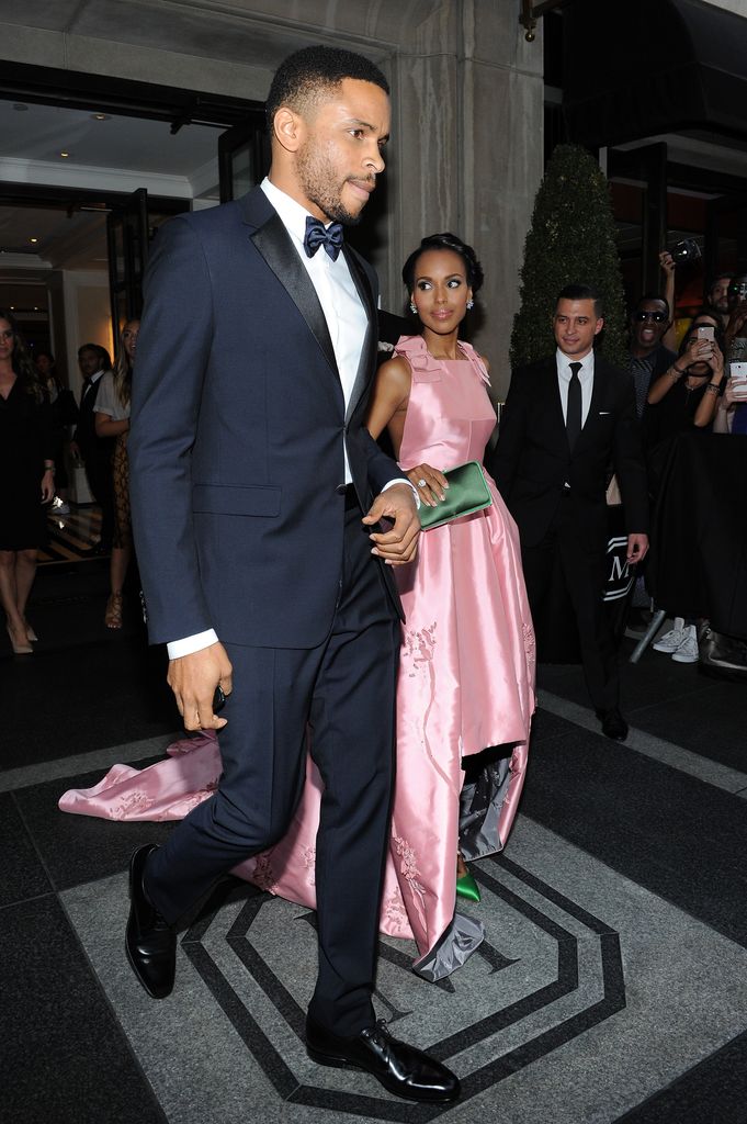 Kerry Washington in a satin pink dress walking next to Nnamdi Asomugha in a suit