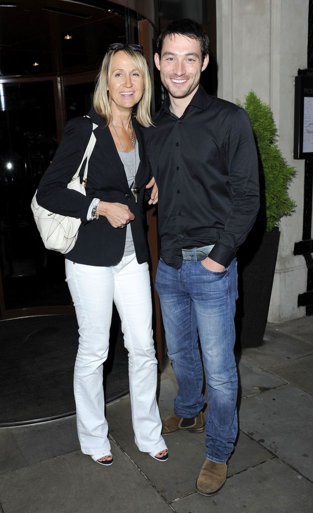 Carol McGiffin in white trousers and a black blazer with Mark Cassidy