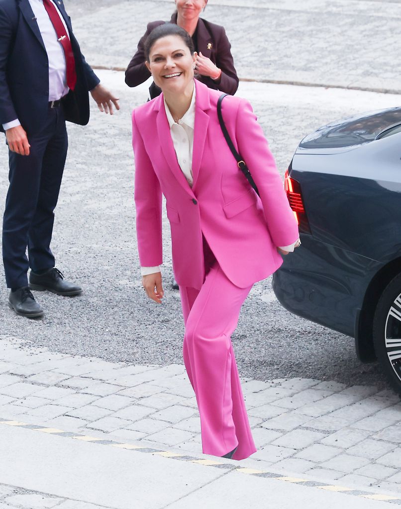 Crown Princess Victoria walking up stairs in pink power suit