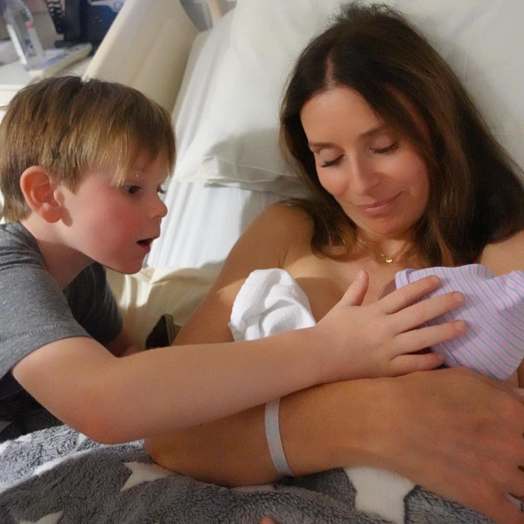 Tana Ramsay holding baby son Jesse while son Oscar watches over them