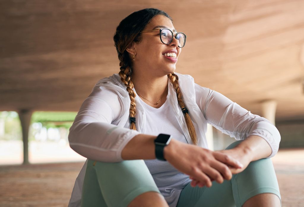 Photo d'une jeune femme sportive prenant une pause tout en faisant de l'exercice à l'extérieur