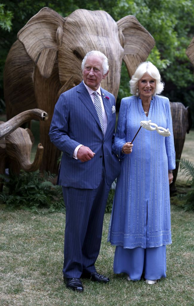 Britain's King Charles III and Britain's Queen Camilla hold masks as they attend the Animal Ball at Lancaster House in London on June 28, 2023, to mark the 20th anniversary of wildlife conservation charity Elephant Family. 