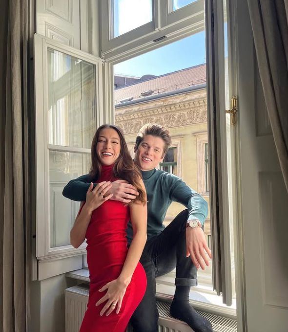 Lewis Cope with his arm around his girlfriend as he sits in a window