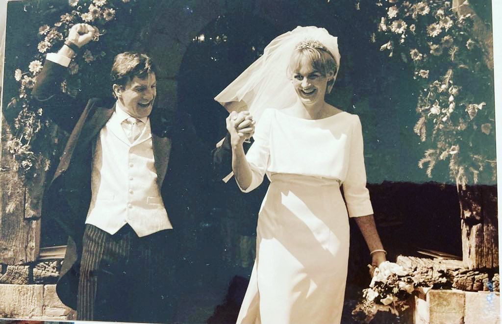 Louise Minchin on her wedding day holding hands with her husband in a simple wedding dress