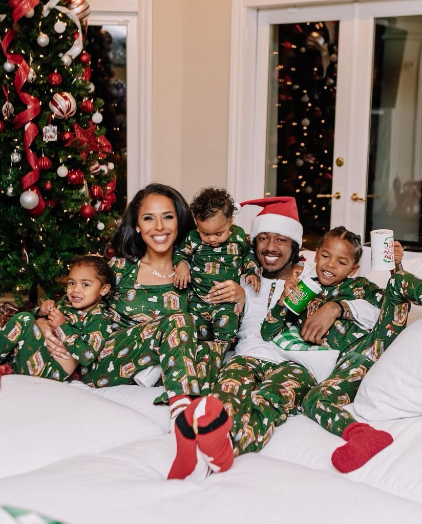 Nick with Brittany Bell and their three children sat on a large white sofa in matching Christmas PJs