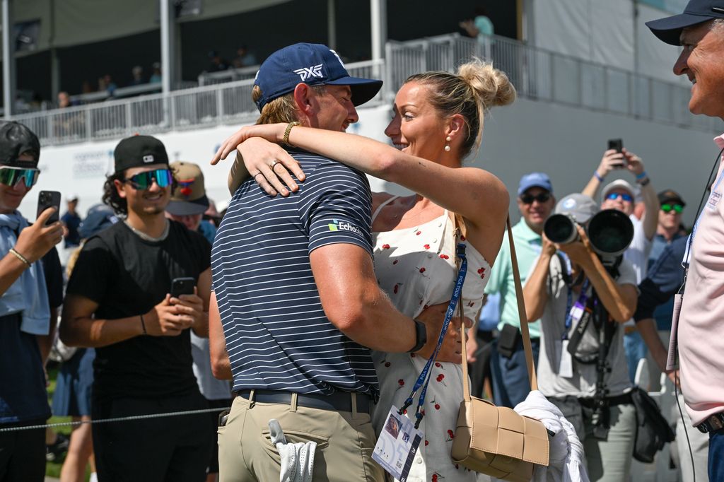 Jake Knapp hugs his girlfriend, Makena White, while walking off the 18th green during the first round of the Cognizant Classic in The Palm Beaches at PGA National Resort the Champion Course in 2025