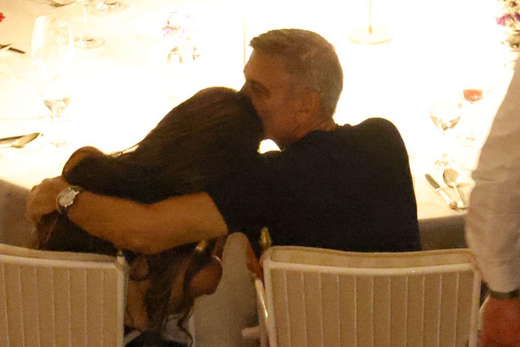 George Clooney kissing Amal at dinner table during meal at Villa D'Este in Italy