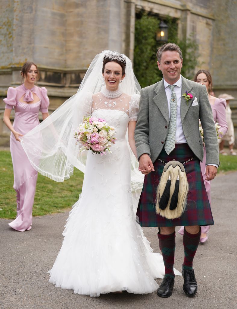 bride in white dress and veil with groom in kilt