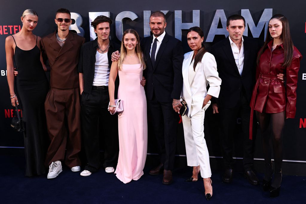 David Beckham (5L) and his wife Victoria Beckham pose pose on the red carpet with their children, and partners, (from L) Mia Regan, Romeo Beckham, Cruz Beckham, Harper Beckham, Brooklyn Beckham and Nicola Peltz Beckham