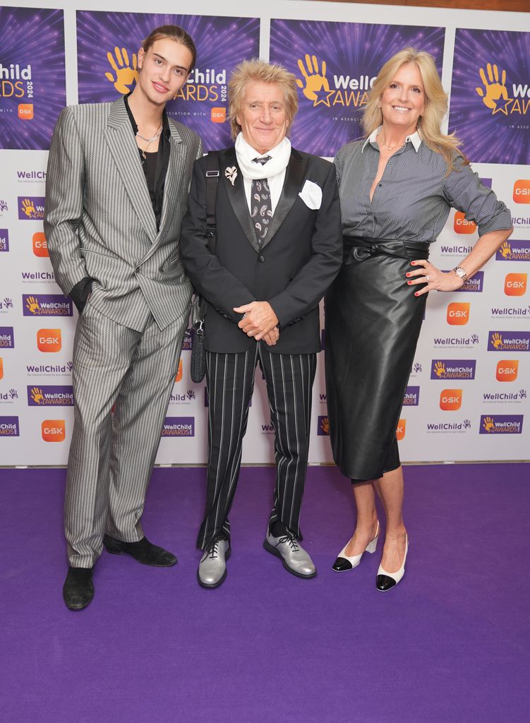 Sir Rod Stewart com Penny Lancaster e seu filho Alastair Wallace Stewart no tapete roxo