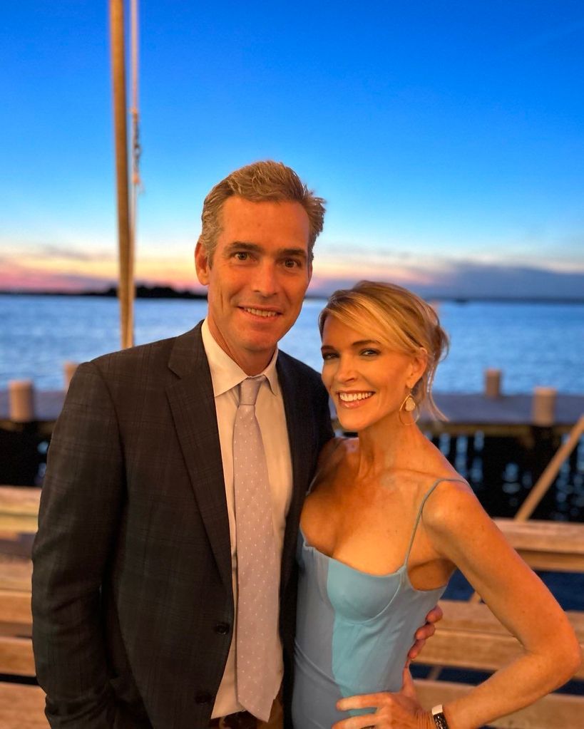 Megyn Kelly and husband Douglas Brunt, dressed formally, smile in front of a gorgeous sunset by the ocean.