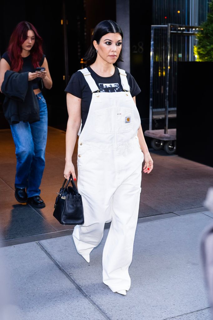 Kourtney Kardashian wearing white dungarees 