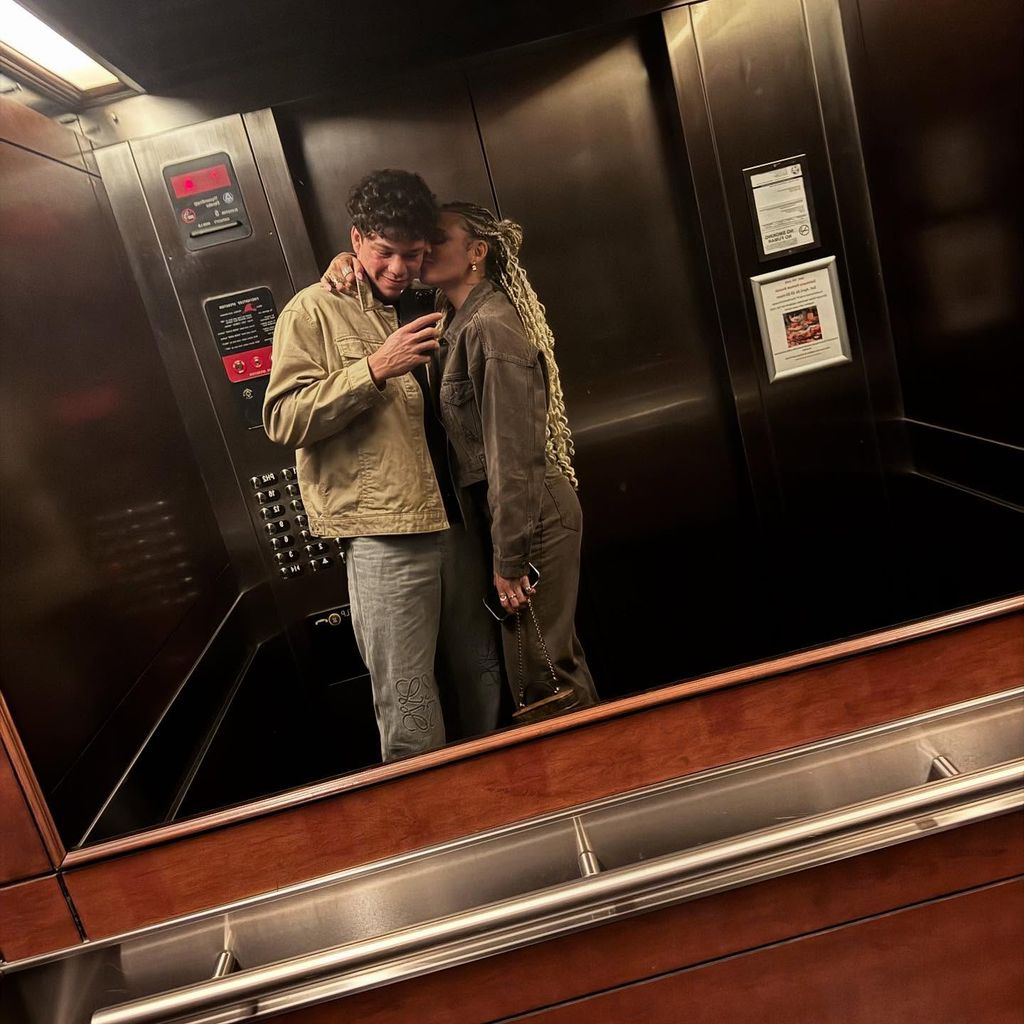 ben shelton in a lift with trinity rodman who is kissing his cheek