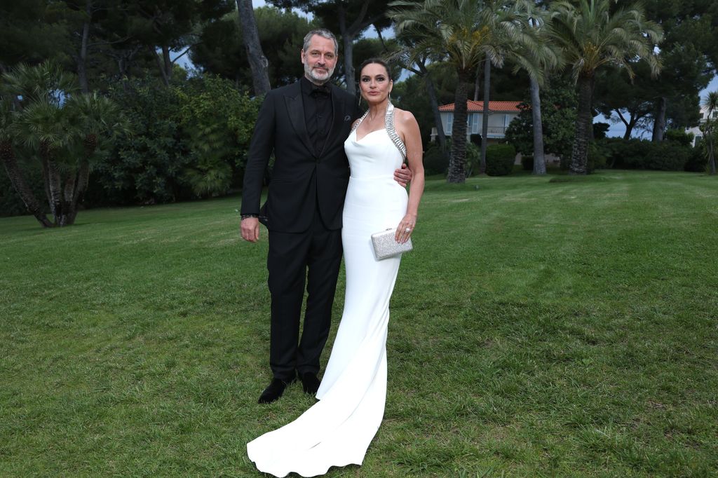 mariska hargitay in white dress with peter hermann in black suit standing on grass