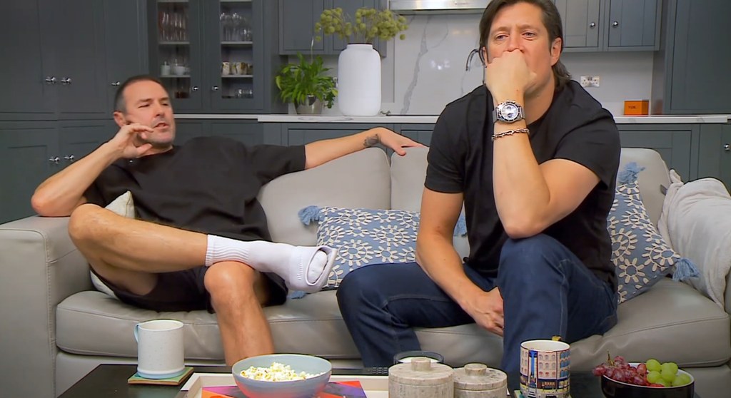 Paddy McGuinness and Vernon Kay siting on grey leather sofa with kitchen in the background