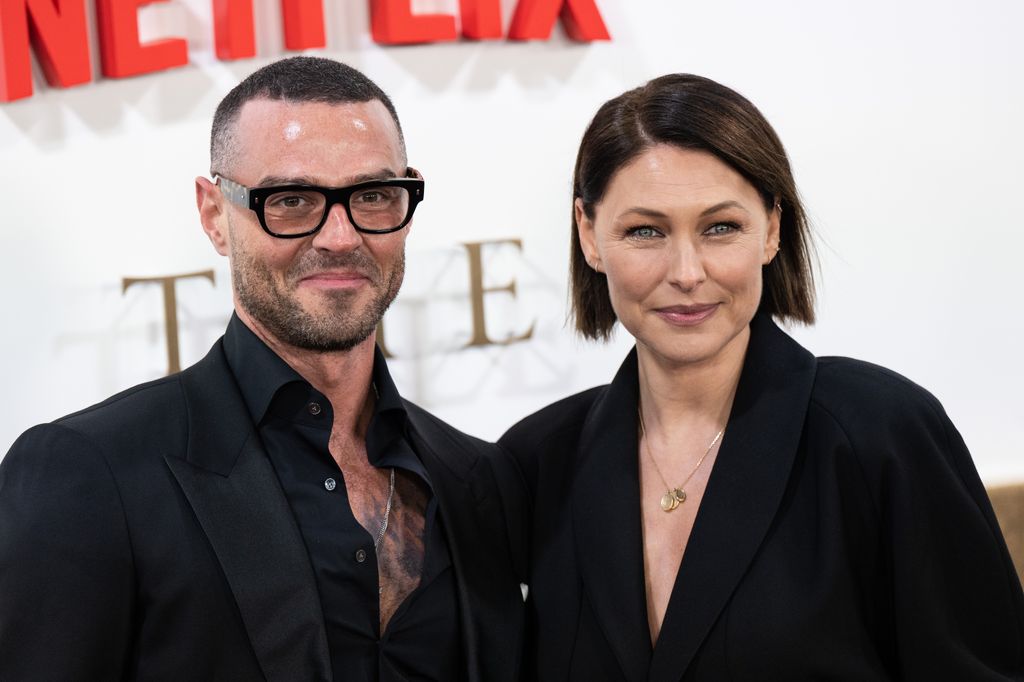 couple smiling for cameras on red carpet