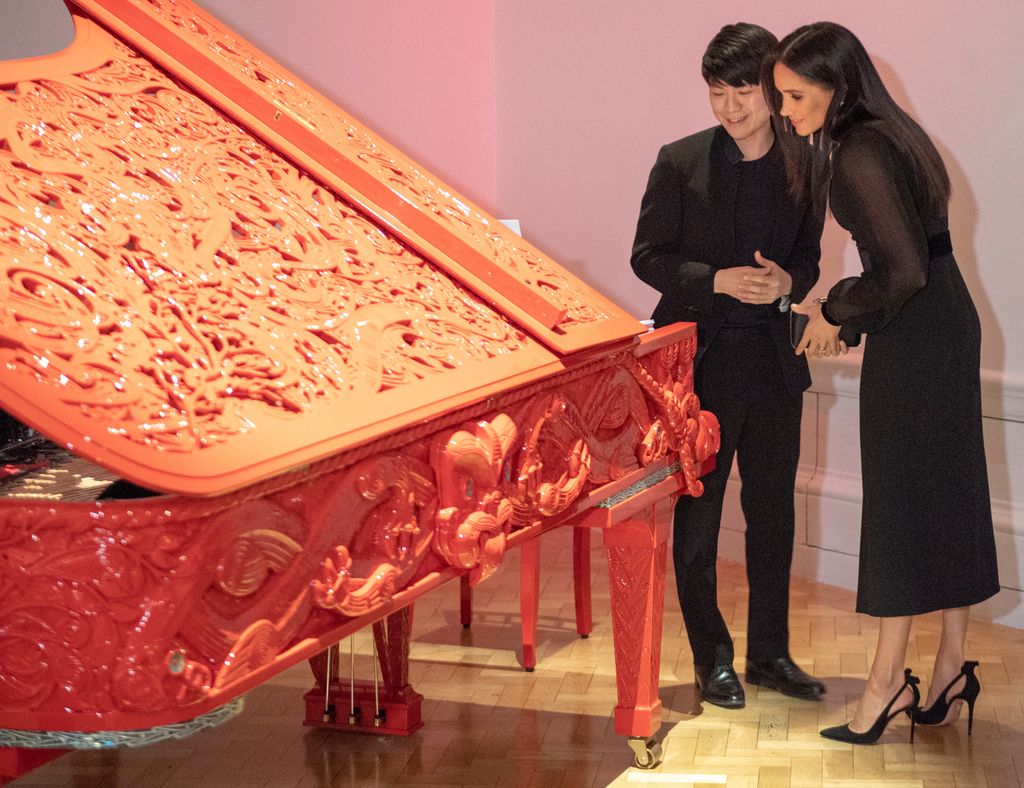 Meghan, Duchess of Sussex standing by piano