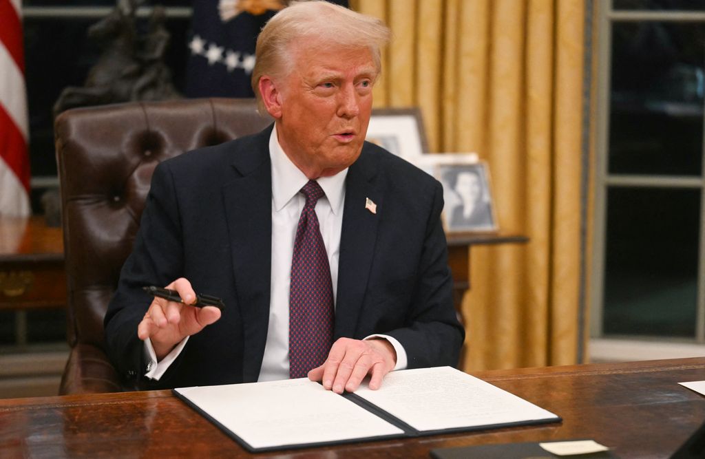 US President Donald Trump signs an executive order on the US withdrawal from WHO (World Health Organization) in the Oval Office of the WHite House in Washington, DC, on January 20, 2025