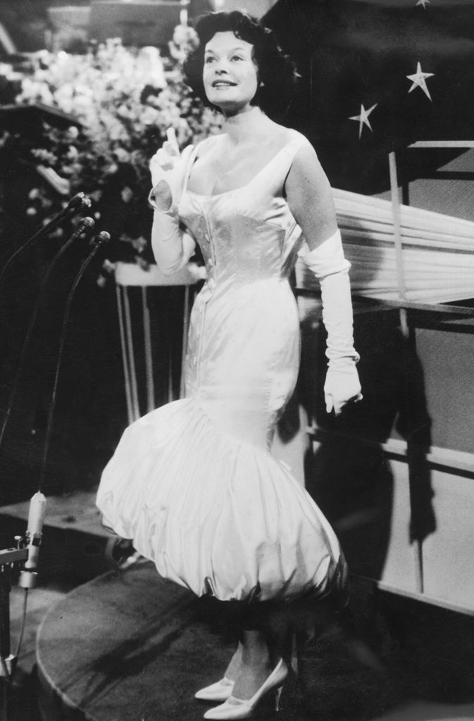 Margot Hielscher wears a vintage bubble-hem satin gown with gloves and heels at the first Eurovision in 1956.