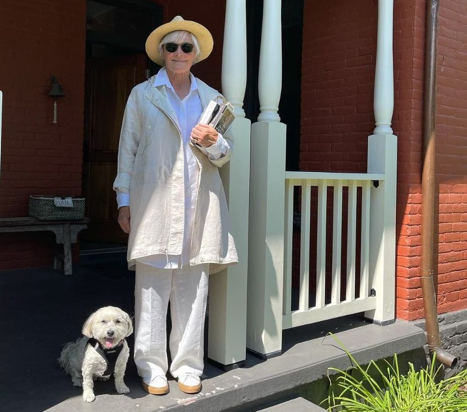 photo of glenn close standing on her porch at montana home beside her dog