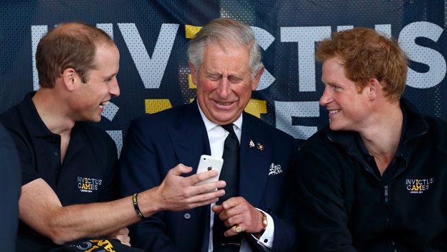 king charles laughing at prince williams phone next to prince harry