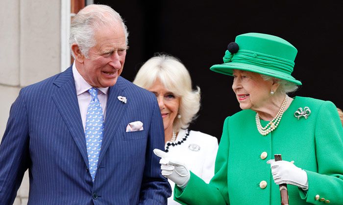 Prince Charles smiles as he listens to his mother, the Queen