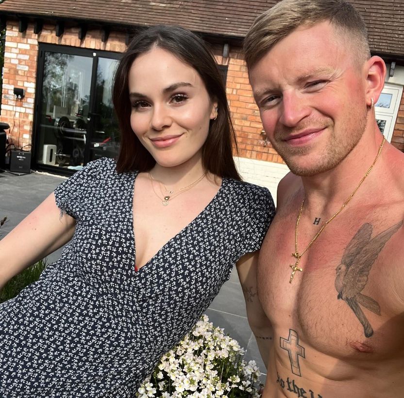 Holly Ramsay in a black dress and a shirtless Adam Peaty in a garden