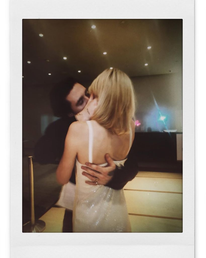 Nicola Peltz in a white sequin mini dress kissing Brooklyn Beckham