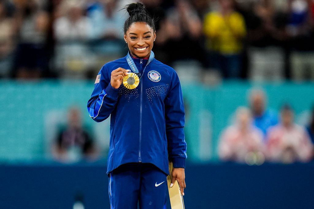 Simone Biles on the podium in blue outfit