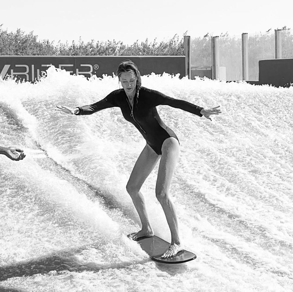 Storm Keating in a long-sleeve swimsuit surfing