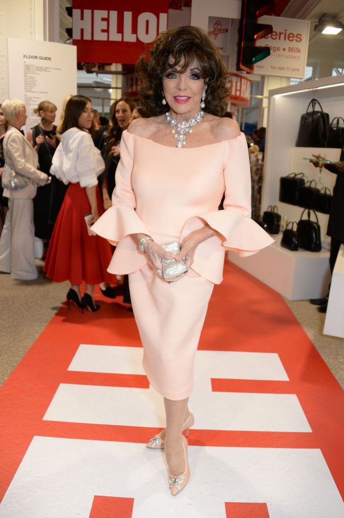 Dame Joan Collins posed at party in light pink dress
