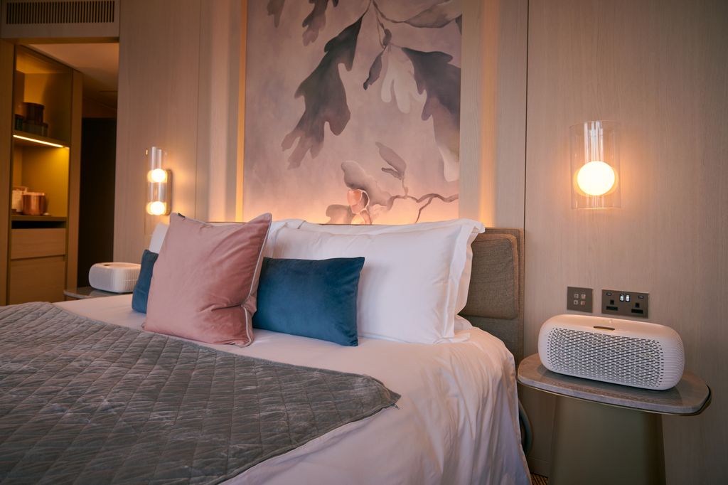 plush bed with white cooling devices either side 