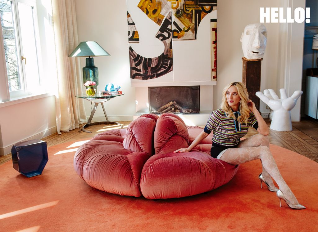 The living area featuring features vintage aluminium fireplace panels, a red- pink vintage JP Demeyer & Co velvet sofa and a handcrafted wooden sculpture of a head in the three-storey apartment in Antwerp’s Graanmarkt Square 