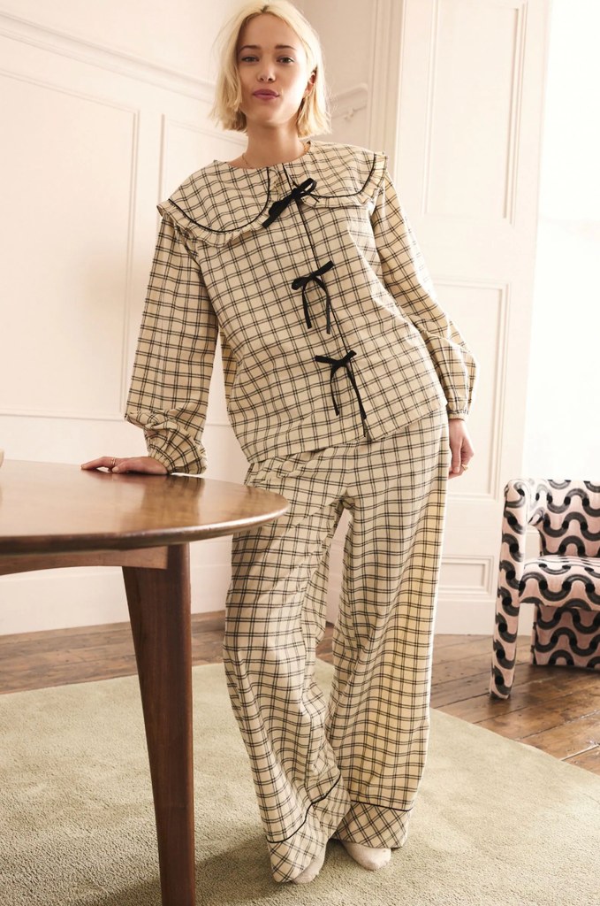 A blonde model poses in black and cream checkered pyjamas 