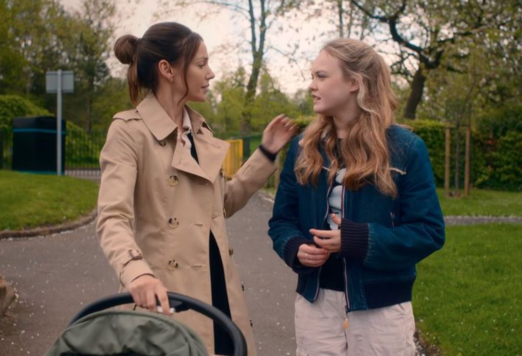 Michelle's character Mia wears her trench coat with a navy sweater on the Netflix show