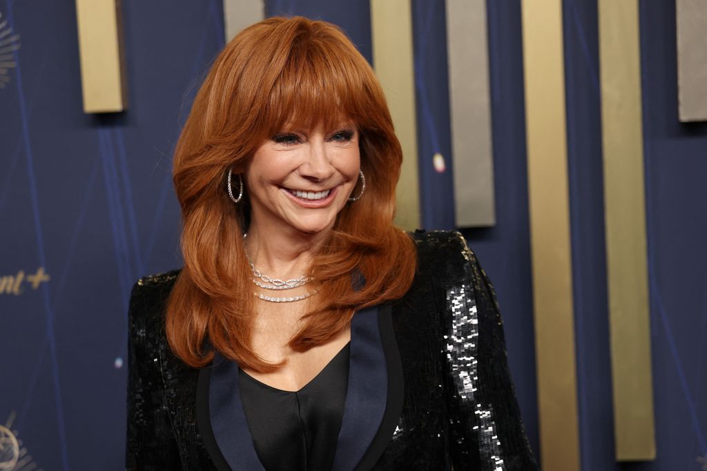 Reba McEntire smiling in a sparkly black jacket 