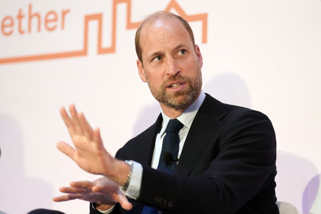 Prince William moving his hands around in a black suit
