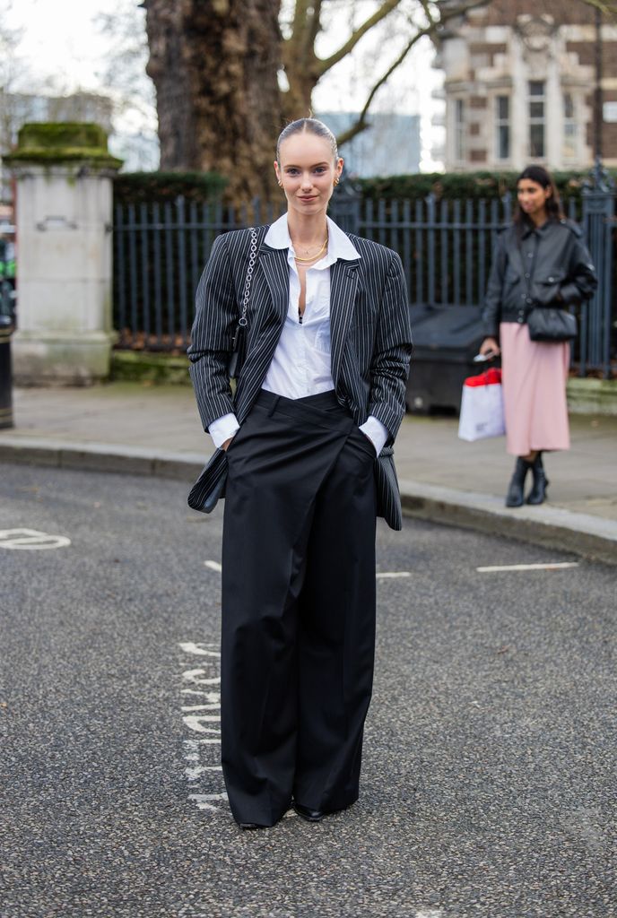 LONDON, ENGLAND - FEBRUARY 18: A guest wears black white oversized blazer, black pants, white button shirt outside Holzweiler during London Fashion Week February 2024 on February 18, 2024 in London, England. (Photo by Christian Vierig/Getty Images)