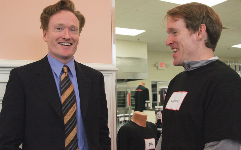 LAWRENCE, MA - SEPTEMBER 25: Labels Are For Jars (LAFJ) and Cor Unum announced today the successful completion of the Cor Unum Meal Center, a 5,600 square foot facility that will help feed hungry families in Lawrence starting Sept. 30. LAFJ member Conan O'Brien, left, and his brother, Luke, right, of Watertown, Mass., joined other leaders to break bread in support of the meal center they helped make possible. (Photo by Janet Knott/The Boston Globe via Getty Images)