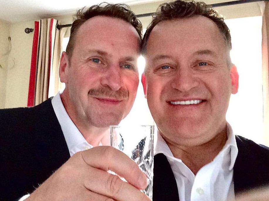 Paul Burrell smiling as his husband held a glass of bubbly
