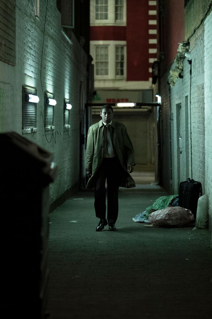 Homme dans un trench-coat marchant sur Daek Alley