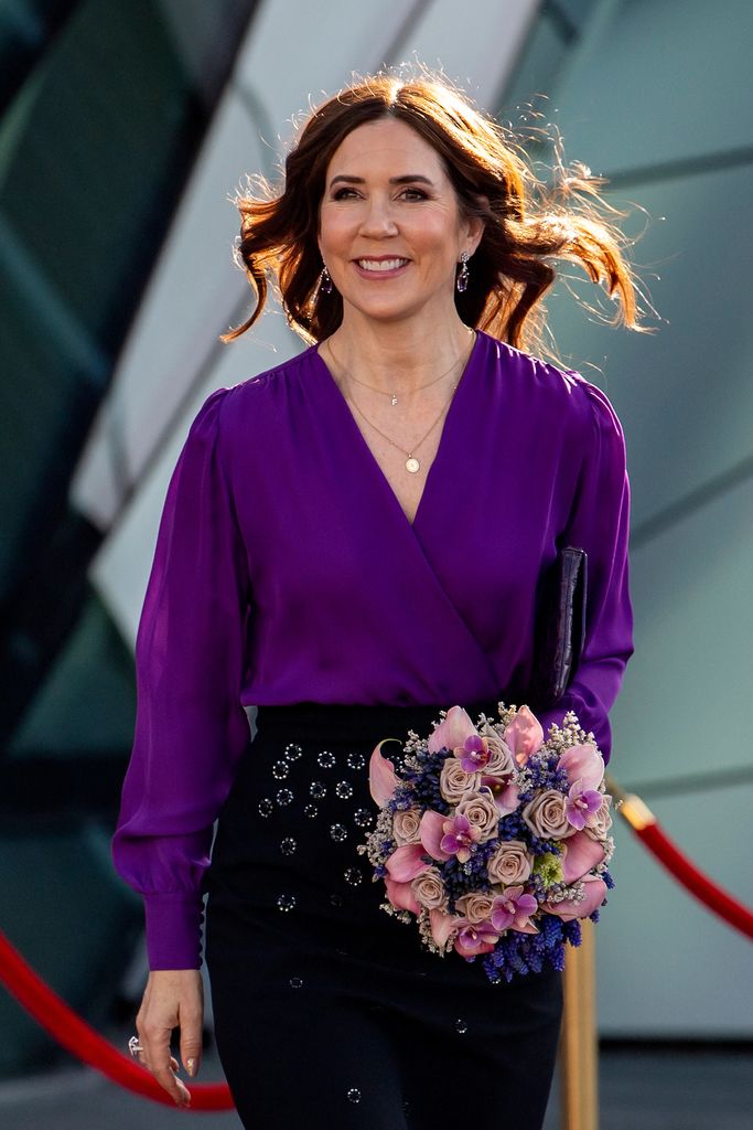 Queen Mary in purple blouse smiling
