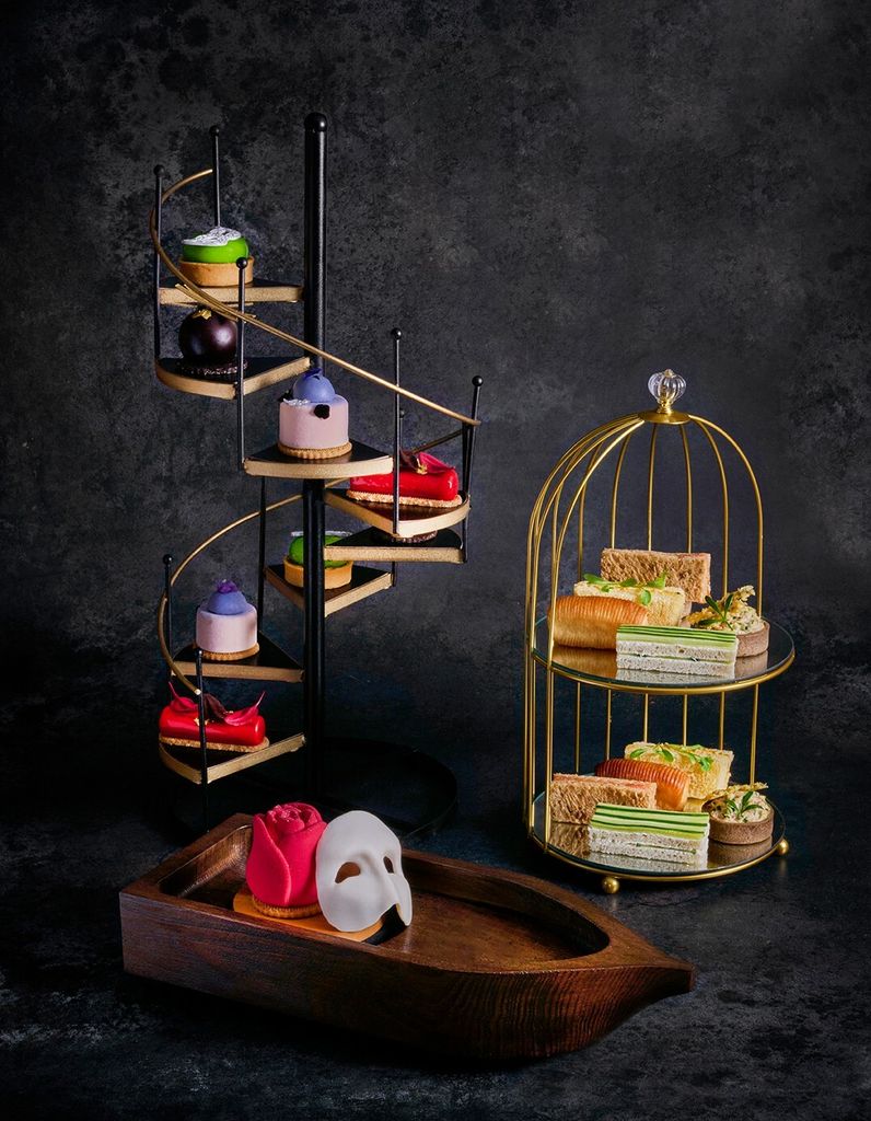 afternoon tea with mini cakes on a staircase and birdcage