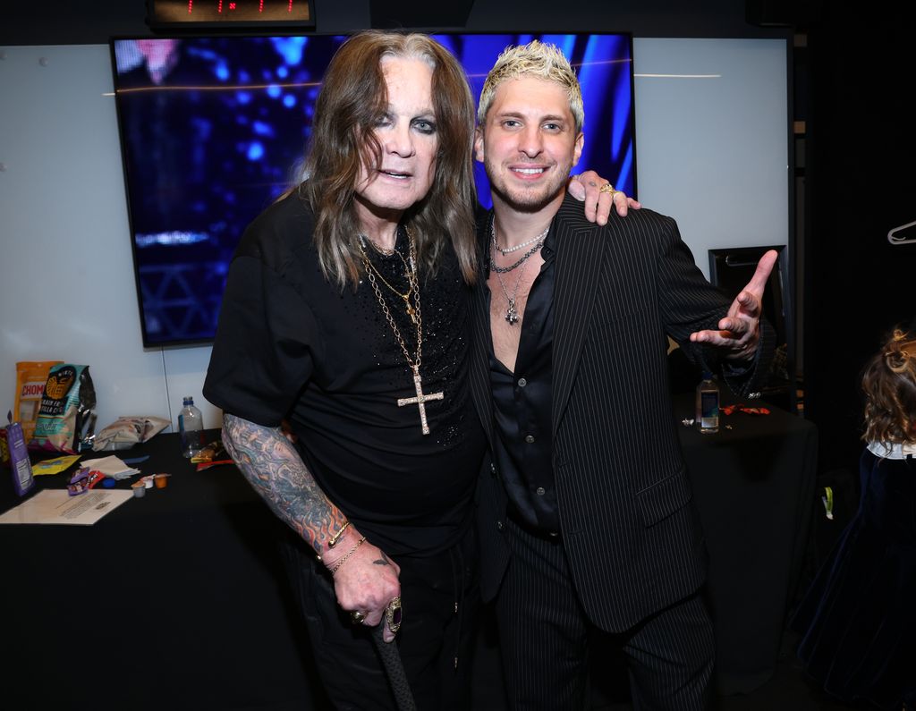 Ozzy Osbourne in black t-shirt posing with Andrew Watt in black shirt at the 