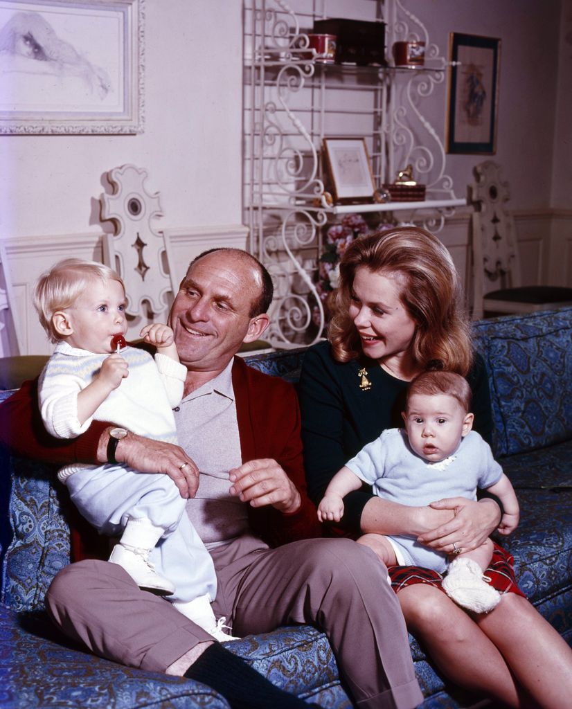 Elizabeth Montgomery at home, sat on the couch with her husband and two children