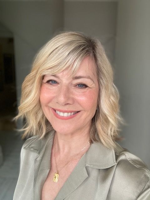 woman smiling with blonde hair wearing a sage green shirt