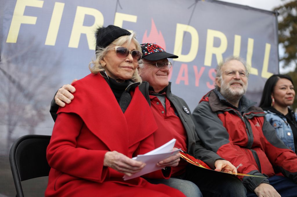 Jane Fonda, Ben Cohen and Jerry Greenfield, co-founders of Ben & Jerry's Ice Cream, listen during a rally prior to a march from the U.S. Capitol to the White House as part of her "Fire Drill Fridays" rally protesting against climate change November 08, 2019 in Washington, DC. The demonstrators temporarily blocked the White House northwest gate and said they were ready to be arrested. No one was arrested before they ended the protest and ate free ice cream